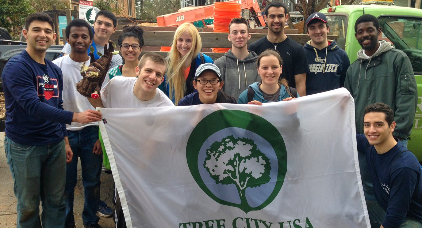 A group of GT students volunteers holding a Tree City banner..